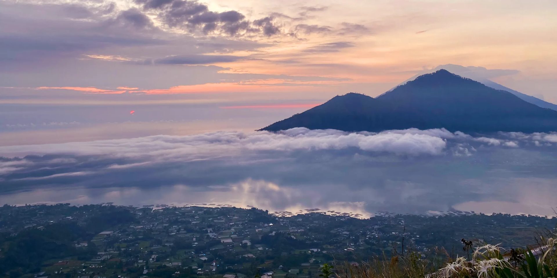 Mountain summit rising above a sea of clouds at dawn